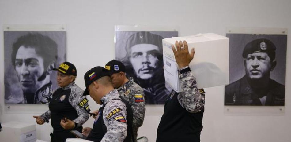 Miembros de la Policia Nacional Bolivariana de Migracipon desempacan artículos a utilizar para prevención del coronavirus. Foto: AP.
