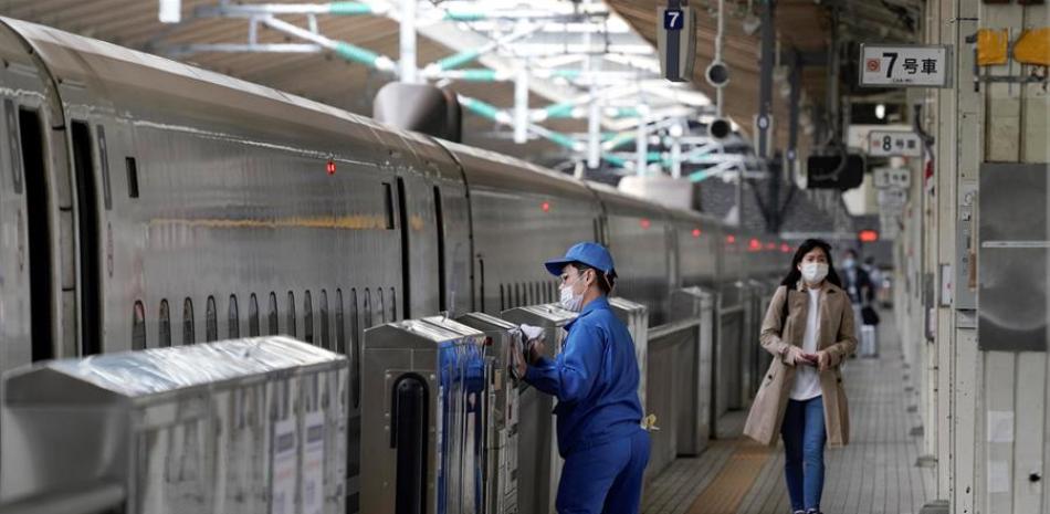 Un empleado del metro de Tokio desinfecta el acceso a los vagones. EFE/EPA/KIMIMASA MAYAMA