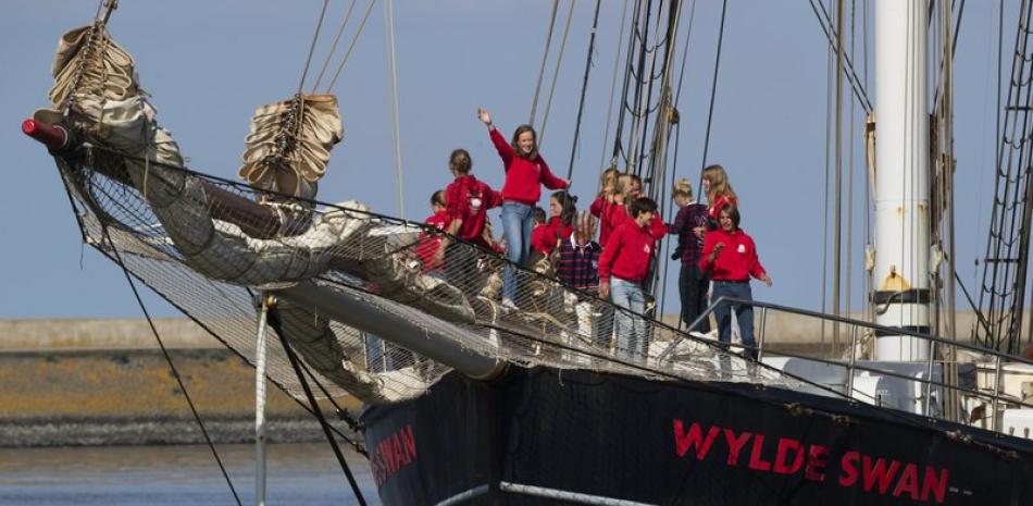 Adolescentes holandeses a bordo del barco de vela Wylde Swan después de cruzar el Atlántico para llegar al puerto de Harlingen, en el norte de Holanda, el domingo 26 de abril de 2020. (AP Foto/Peter Dejong)