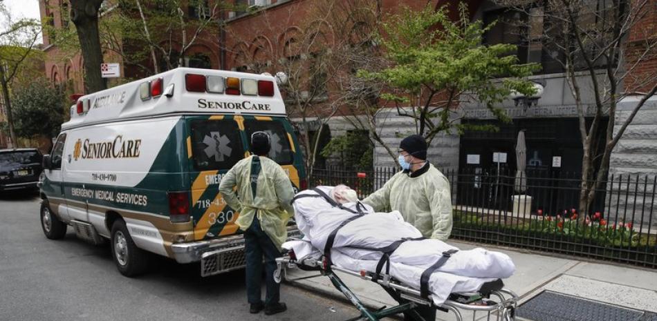 En imagen de archivo del 17 de abril de 2020, un paciente es trasladado en una camilla afuera del Centro de Salud Cobble Hill por personal médico de emergencias en Brooklyn, Nueva York. (AP Foto/John Minchillo, archivo)