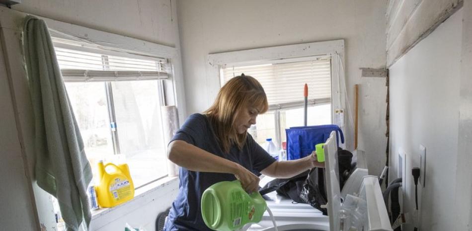 Pie: Fotografía muestra a Lissette Serrano lavando ropa mientras hace sus labores diarias en su casa en Bridgeport, Connecticut. (AP Foto/Mary Altaffer)