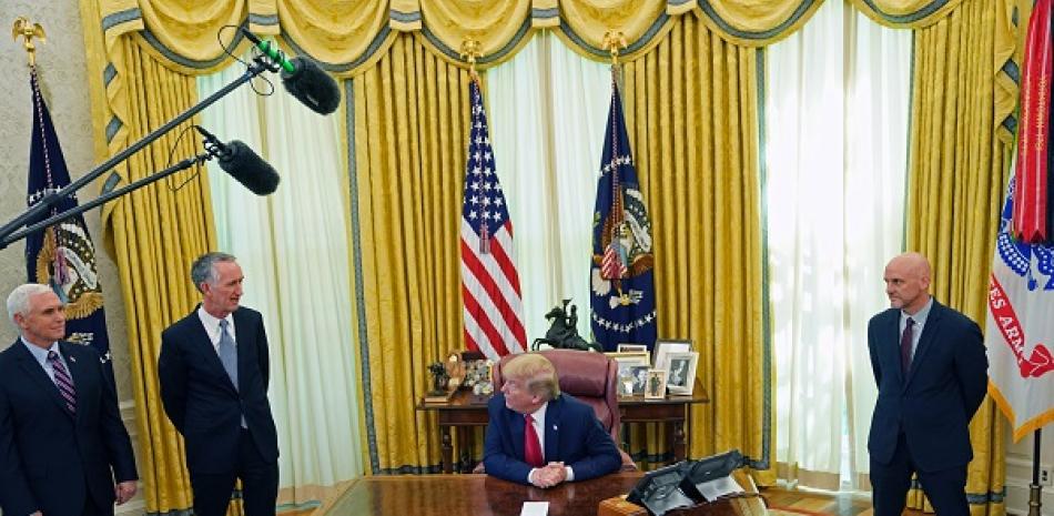 El presidente Donald Trump habla con Daniel O’Day (de pie junto al vicepresidente Mike Pence), director general de Gilead, la empresa que fabrica el remdesivir, en el Despacho Oval de la Casa Blanca en Washington, el 1.° de mayo de 2020. (Erin Schaff/The New York Times)
