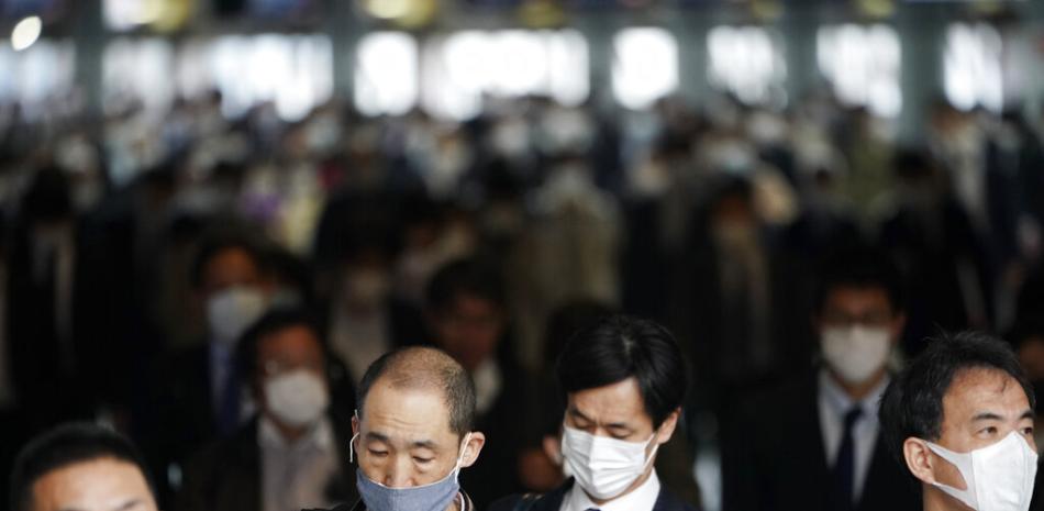 Pasajeros con tapabocas en una estación de trenes de Tokio el 27 de abril del 2020. Hay quienes se pregutan si Japón estará en condiciones de montar los Juegos Olímpicos dentro de 15 meses tras su aplazamiento de un año por el coronavirus. (AP Photo/Eugene Hoshiko)