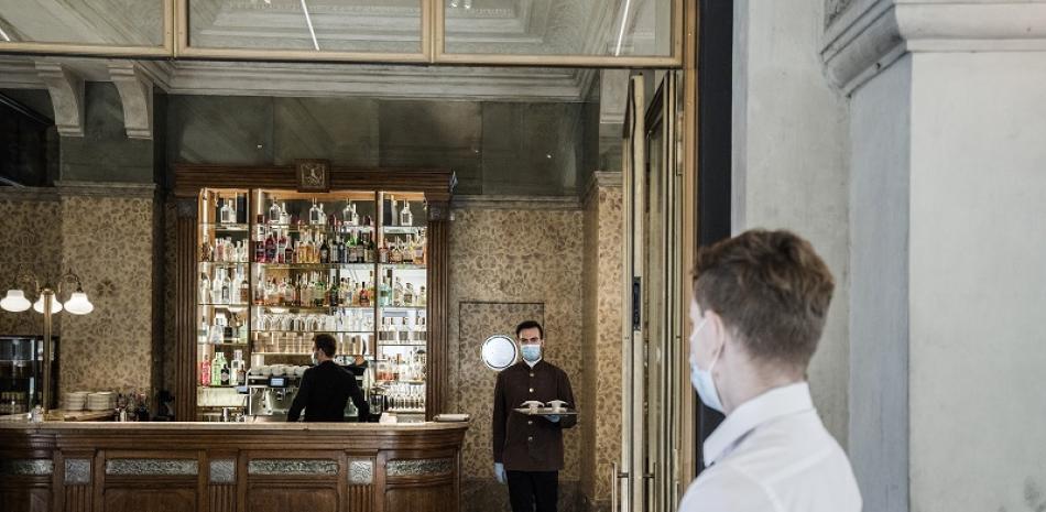 Un hombre con cubrebocas espera su café en un restaurante de Milán, el 4 de mayo de 2020. (Alessandro Grassani/The New York Times)
