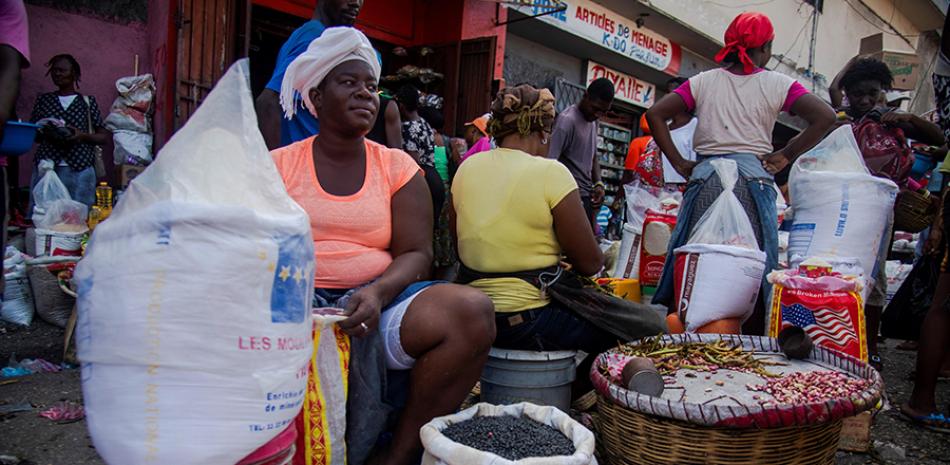 En Haití los ciudadanos siguen asistiendo de manera masiva a mercados y usando autobuses públicos. EFE / AFP