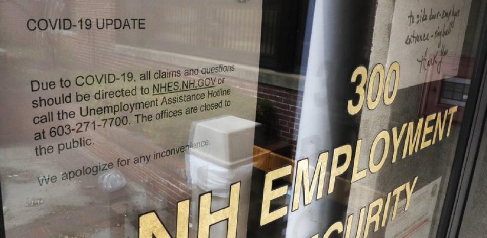 Foto de archivo del centro de seguridad laboral en Manchester, Nueva Hampshire. El cartel indica cómo pedir prestaciones por desempleo. El gobierno informó el viernes 8 de mayo de 2020 que la tasa de desempleo llegó al 14,7%, la más alta desde la Gran Depresión. (AP Foto/Charles Krupa, File)
