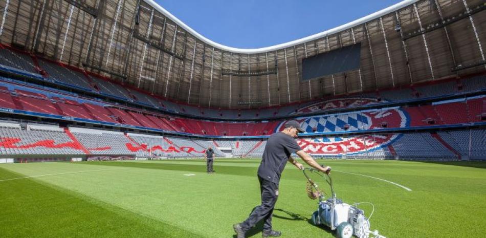 Empleados del Bayern Munich realizan trabajos sobre el terreno de su estadio para la reanudación de la liga alemana de primera división.