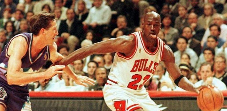 En esta foto de archivo tomada el 4 de junio de 1997 Michael Jordan saca la lengua al pasar frente a Jeff Hornacek, del Utah Jazz, durante el Juego Dos de las Finales de la NBA. Fuente: Vincent Laforet/AFP.
