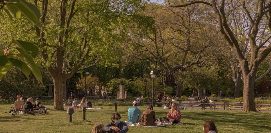 Personas descansando, algunas con cubrebocas, en el Washington Square Park en Nueva York, el 14 de mayo de 2020. (Jeenah Moon/The New York Times)
