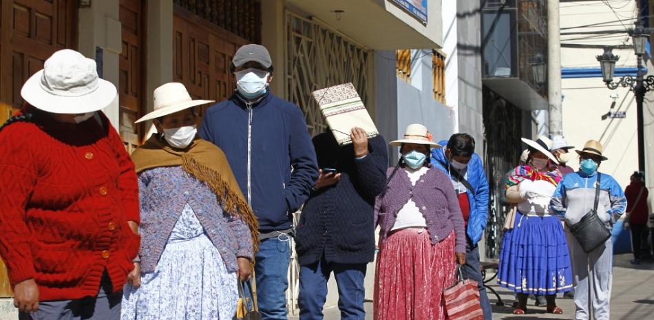 Personas hacen filas para solicitar el retiro de fondos de la AFP en la ciudad de Puno, cerca de la frontera con Bolivia, en Perú. AGENCIA AFP.