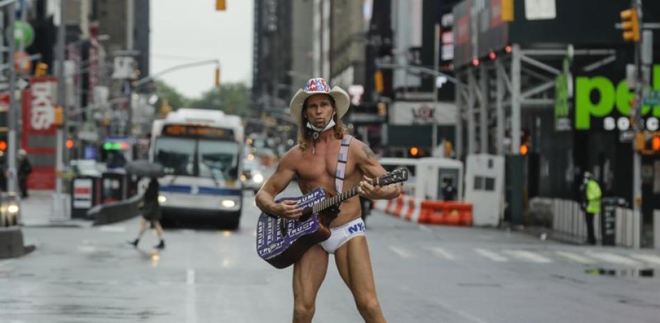 Robert Burck, el Naked Cowboy (Vaquero desnudo), posa para los fotógrafos en Times Square durante la pandemia de coronavirus en Nueva York, el sábado 23 de mayo de 2020. (AP Photo/Frank Franklin II)
