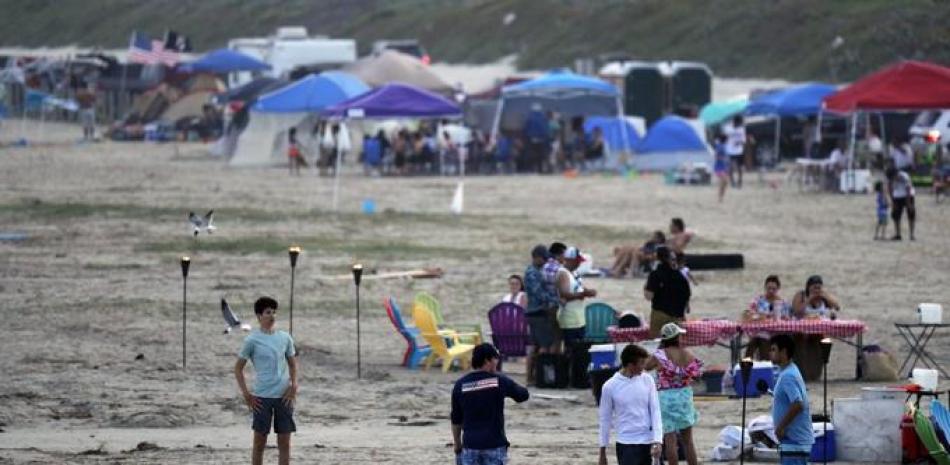 Cientos de personas disfrutan de la playa el sábado 23 de mayo de 2020, en el fin de semana feriado por el Día de los Caídos en las Guerras, en Port Aransas, Texas, en medio de la pandemia del coronavirus. (AP Foto/Eric Gay)