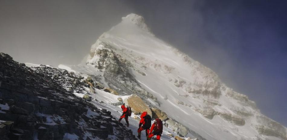 En esta imagen, distribuida por la agencia de noticias Xinhua, miembros de un equipo chino de medición se dirigen a la cima del Monte Everest, conocido localmente como Monte Qomolangma, el 27 de mayo de 2020. (Tashi Tsering/Xinhua via AP)
