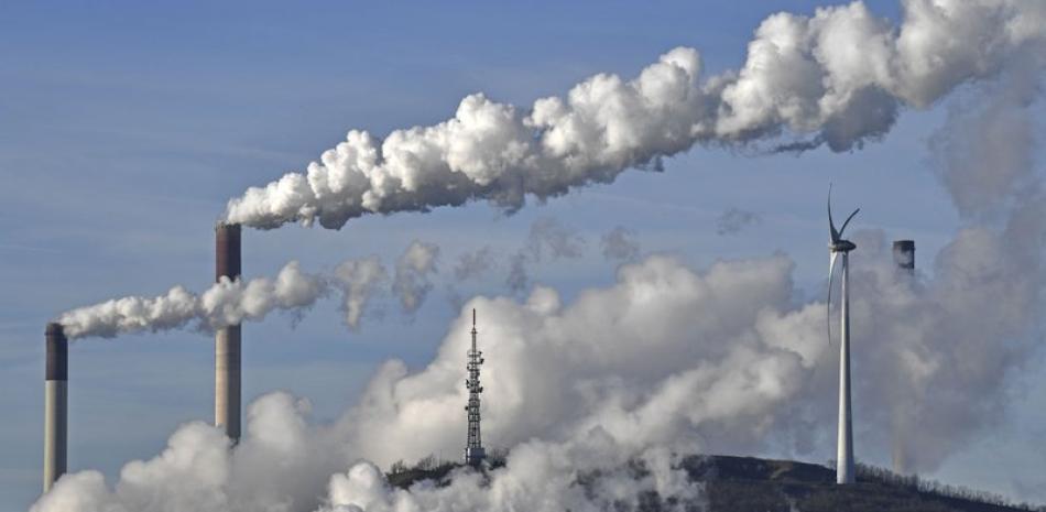 ARCHIVO - En esta fotografía del 16 de enero de 2020 se muestra una termoeléctrica a carbón de la compañía Uniper y una refinería de BP junto a un generador eólico en Gelsenkirchen, Alemania. (AP Foto/Martin Meissner)