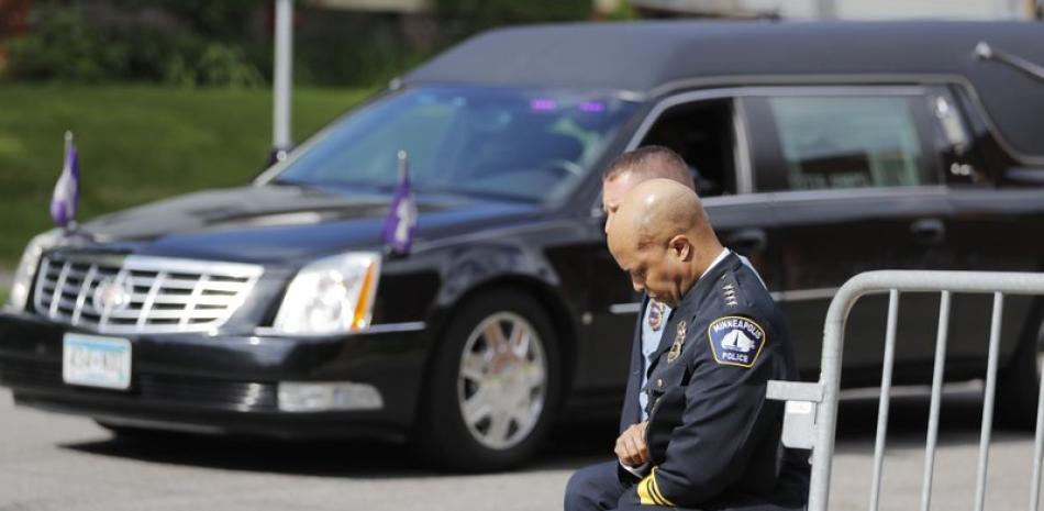 Agentes de la policía, incluido el jefe de la policía de Minneapolis Medaria Arradondo (en primer plano), se arrodillan mientras arriba el cuerpo de George Floyd previo a su funeral el jueves 4 de junio de 2020, en Minneapolis. (AP Foto/Julio Cortez)