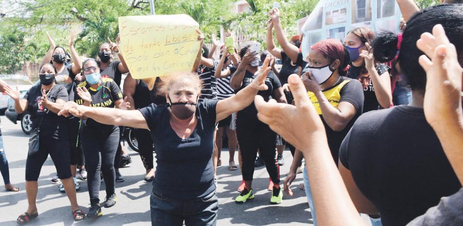 Una mujer alza sus brazos durante la protesta ayer en Capotillo para denunciar los alegados atropellos contra ciudadanos de la barriada en las redadas de la Policía. / VÍCTOR RAMÍREZ/LD