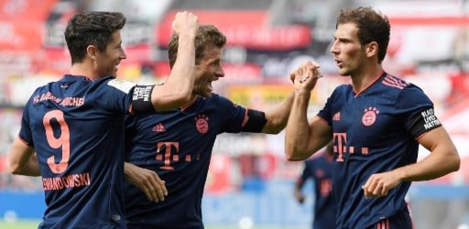 El delantero polaco del Bayern Múnich Robert Lewandowski celebra con sus compañeros del Bayern Múnich, después de anotar el cuarto gol de su equipo durante el partido contra el Bayer 04 Leverkusen. Matthias Hangst/AFP.