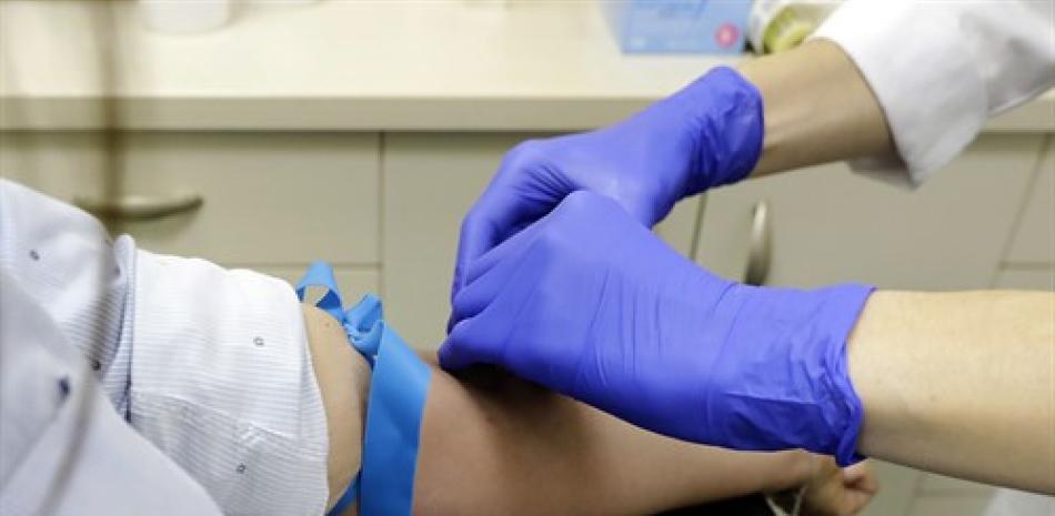 Un trabajador sanitario prepara a una paciente para la extracción de sangre para realizar el test serológico
