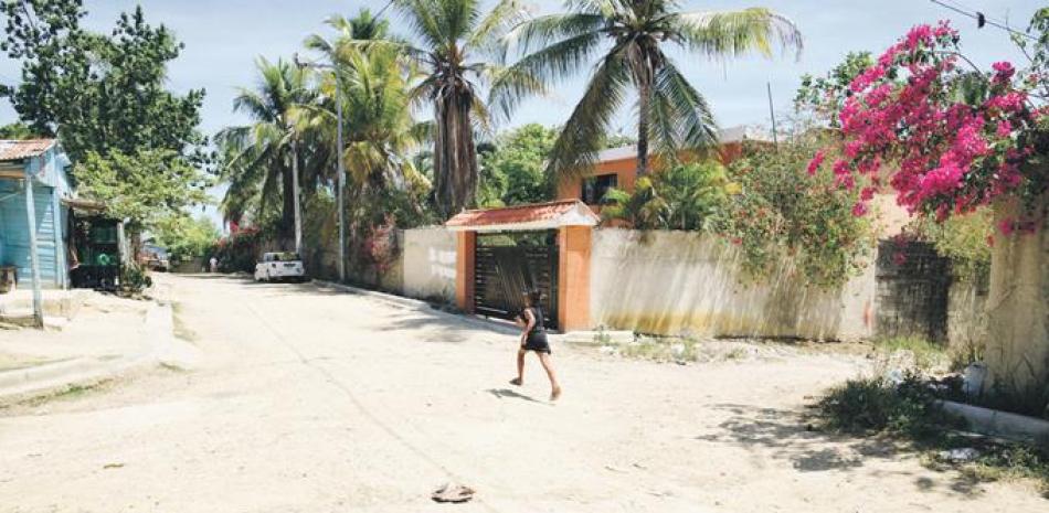 Una niña corre por el frente de la residencia allanada el pasado sábado por el Ministerio Público, luego se recibir denuncias de que en el lugar se celebraba una fiesta violatoria al toque de queda.