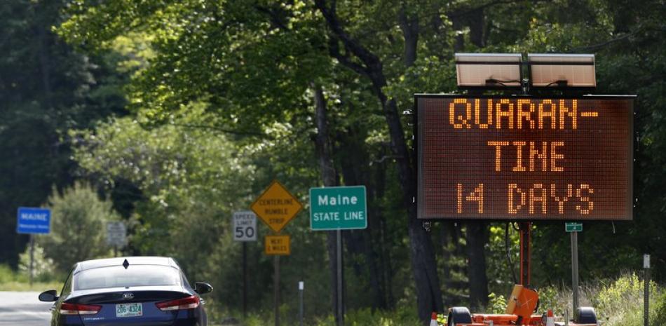 En esta fotografía del miércoles 20 de junio de 2020, un letrero en Gilead, Maine, cerca de la frontera con Nueva Hampshire, advierte a los visitantes que ingresen en Maine que deberán permanecer en cuarentena durante 14 días. Están exentos de la medida quienes provengan de Nueva Hampshire y Vermont. (AP Foto/Robert F. Bukaty)