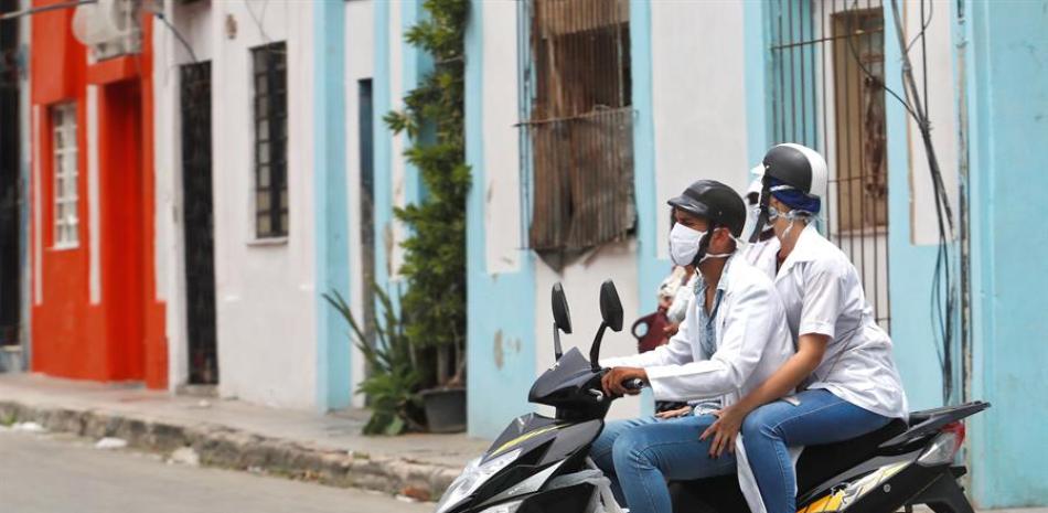 Dos trabajadores de la salud transitan en moto eléctrica este miércoles, en La Habana (Cuba). EFE/Yander Zamora.