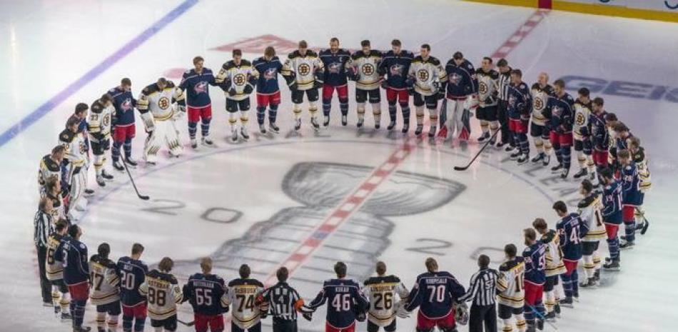 Boston Bruins y Columbus Blue Jackets se unen para los himnos nacionales antes de la acción del juego de exhibición de hockey NHL en Toronto celebrado este jueves.