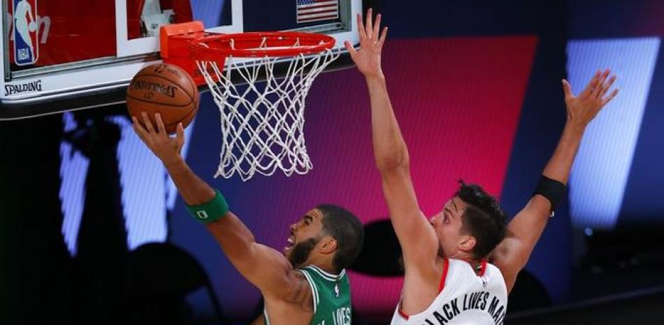 Jayson Tatum (0), encesta por los Celtics de Boston ante Zach Collins, de los Trail Blazers de Portland.