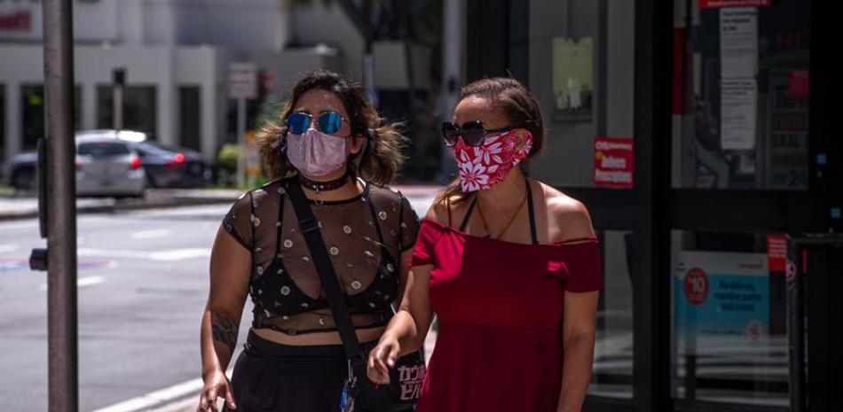 Dos mujeres fueron registradas este domingo con tapabocas al pasear por Miami Beach (Florida, EEUU.). EFE/Giorgio Viera/Archivo