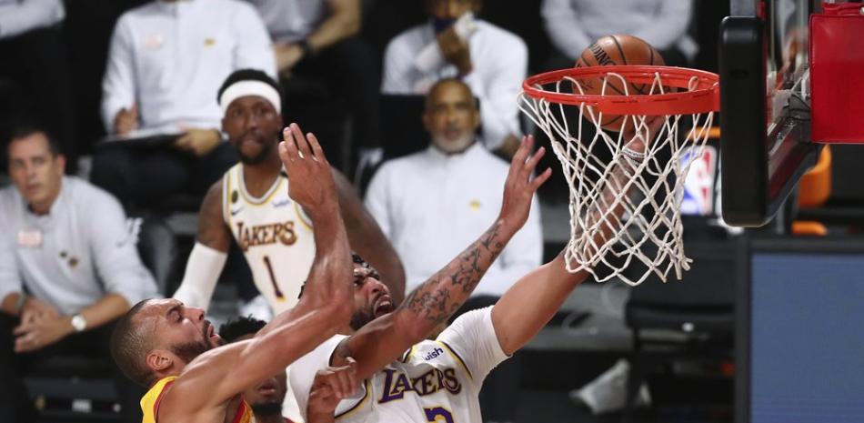 Anthony Davis (3), delantero de Los Angeles Lakers, recibe una falta del centro de Jazz de Utah Rudy Gobert, izquierda,