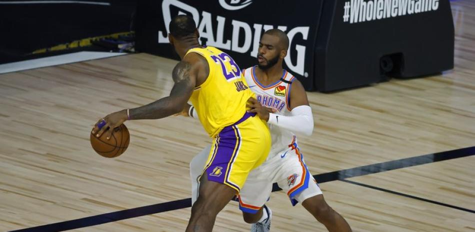 LeBron James (23) de Los Angeles Lakers es defendido por Chris Paul del Oklahoma City Thunder.