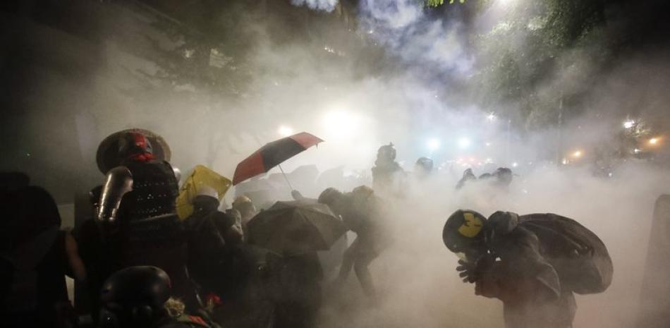 La policía reprime con gases lacrimógenos a manifestantes contra las injusticias raciales en Portland, Oregón, el 26 de julio del 2020. (AP Photo/Marcio José Sánchez, File)