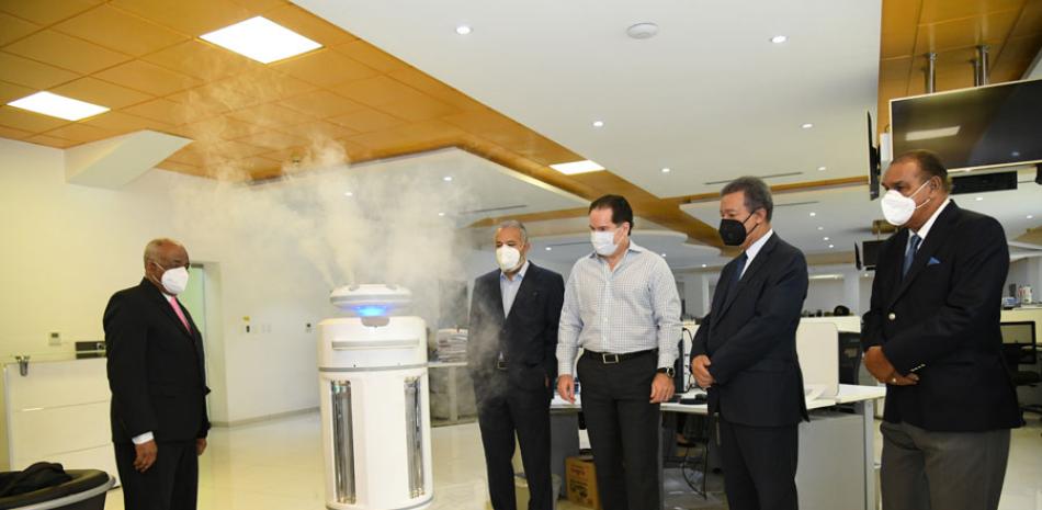 El expresidente Leonel Fernández, en su visita ayer a LISTÍN DIARIO, muestra a ejecutivos del periódico un robot usado para desinfectar espacios cerrados y así evitar contagios por el nuevo coronavirus.