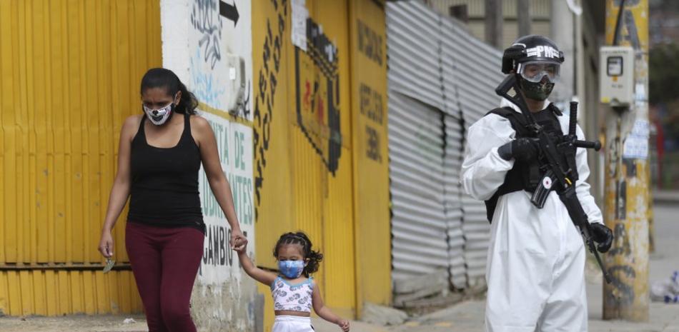 Un soldado con traje protector contra el coronavirus monta guardia el lunes 13 de julio de 2020 en Ciudad Bolivar, un área con una elevada tasa de casos, en Bogotá. (AP Foto/Fernando Vergara)