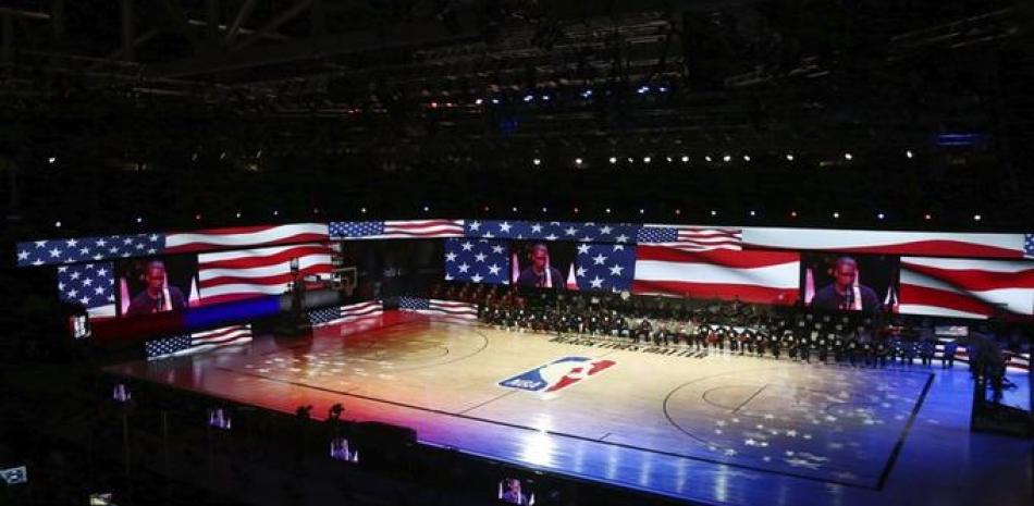 Los Rockets de Houston y los Pacers de Indiana se arrodillan durante la interpretación del himno nacional, antes del partido de la NBA realizado el miércoles 12 de agosto en Lake Buena Vista, Florida .