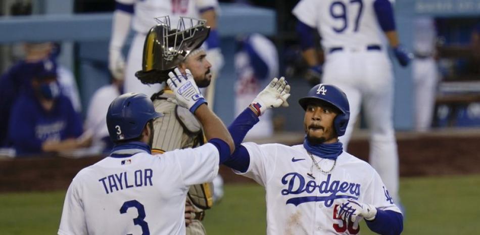 El jugador de los Dodgers de Los Ángeles Mookie Betts,  celebra un jonrón de dos carreras con Chris Taylor en el segundo inning del juego de la MLB que enfrentó anoche a su equipo con los Padres de San Diego, en Los Ángeles. (AP Foto/Jae C. Hong)