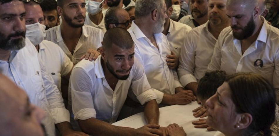Parientes y amigos del bombero Ralph Malahi, de 23 años, muerto en la explosión del 4 de agosto que arrasó el puerto de Beirut, asisten a su funeral, sábado 15 de agosto de 2020. (AP Foto/Felipe Dana)