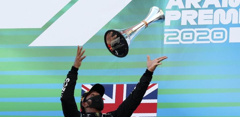 El piloto de Mercedes Lewis Hamilton arroja su trofeo tras ganar el Gran Premio de España de Fórmula Uno en el circuito Barcelona Catalunya en Montmeló, España, este domingo. (AP)