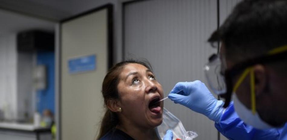 Un trabajador de la salud utiliza un hisopo para recolectar una muestra en un centro de pruebas temporal para el nuevo coronavirus en Madrid. Oscar del Pozo/AFP.