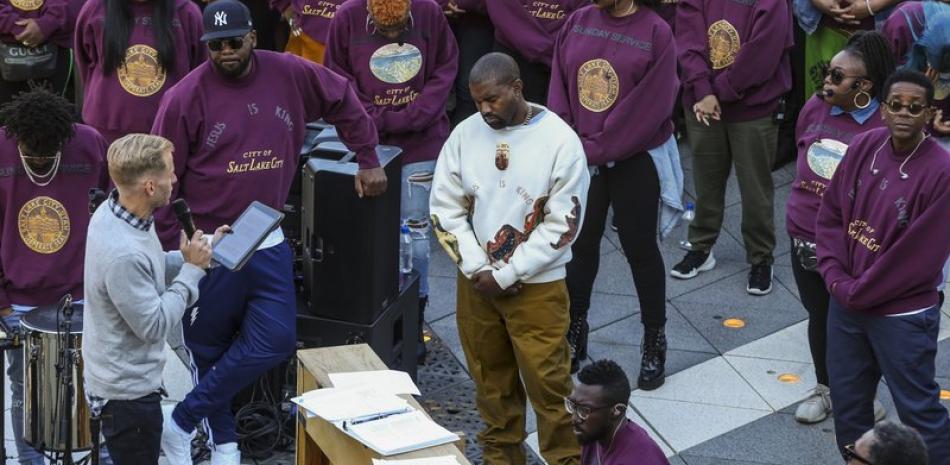 Kanye West, en el centro, inclina la cabeza en oración durante su "Servicio Dominical" en The Gateway en Salt Lake City. Foto: Colter Peterson/AP.