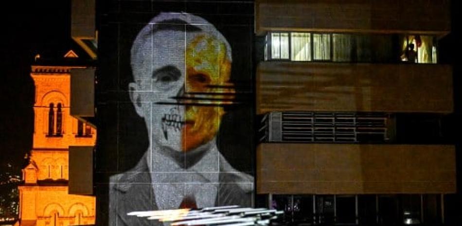 Fotografía de Alvaro Uribe proyectada en la pared de un edificio. / AFP