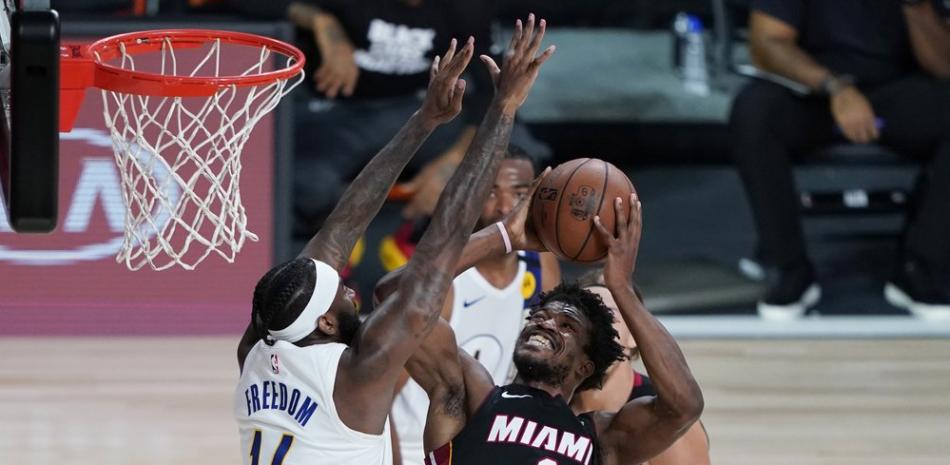 El alero de los Miami Heat Jimmy Butler (22) conduce hacia la canasta contra el alero de los Indiana Pacers JaKarr Sampson (14) durante la segunda mitad de un juego de playoffs de primera ronda de baloncesto de la NBA, este, sábado 22 de agosto de 2020, en Lake Buena Vista, Florida.