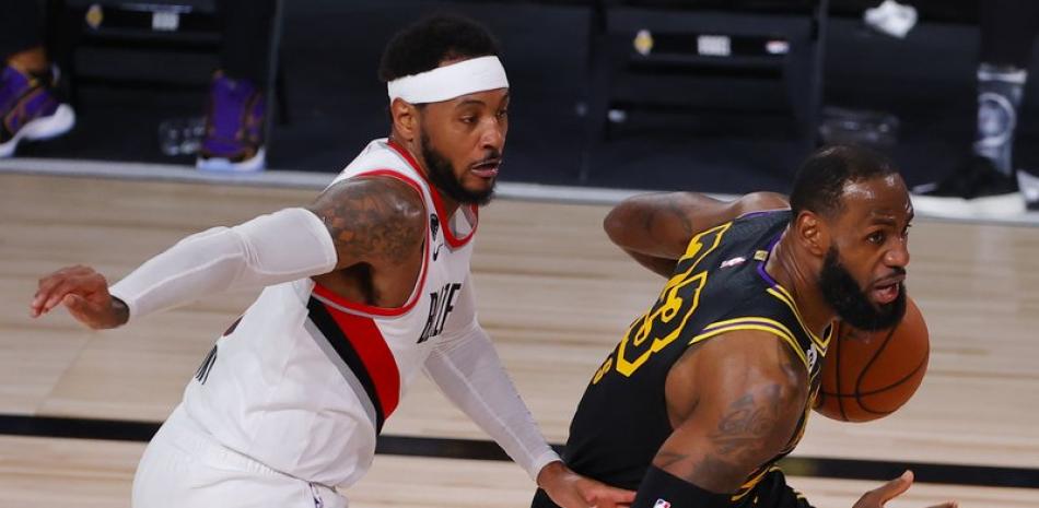 El jugador de los Lakers de Los Ángeles LeBron James, conduce la pelota ante su rival de los Trail Blazers de Portland Carmelo Anthony, en el segundo cuarto del juego de la serie de playoffs de la NBA. (AP)