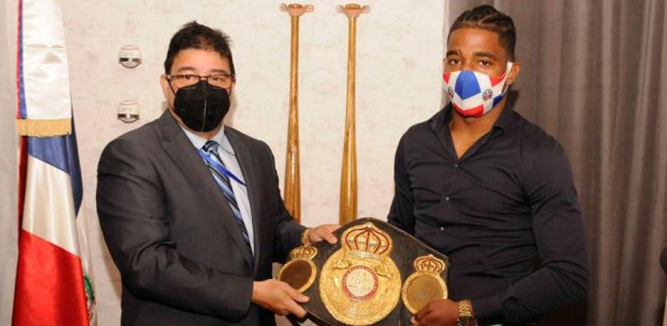 El ministro Francisco Camacho hace entrega de una faja simbólica al boxeador Jackson Maríñez, quien perdió ante Rolando Romero en una pelea de decisión dudosa.