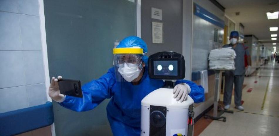 Un trabajador de la salud se hace una selfie con el robot “LaLuchy Robotina” en el Centro Médico Nacional. Claudio Cruz/AFP.