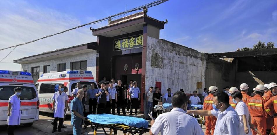 Rescatistas y médicos se reúnen cerca del lugar en donde se derrumbó un restaurante de dos plantas en Xiangfen, en la provicina Shanxi de China, el sábado 29 de agosto de 2020. (Chinatopix vía AP)
