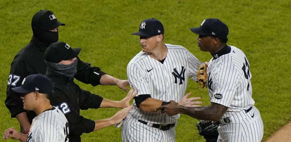 DJ LeMahieu de los Yankees de Nueva York detiene al lanzador de relevo de los Yankees de Nueva York Aroldis Chapman, a la derecha, luego de que él y los Rays de Tampa Bay intercambiaran palabras al final de un juego de béisbol, este martes 1 de septiembre de 2020 en el Yankee Stadium de Nueva York . El incidente ocurrió después de que Chapman lanzó un lanzamiento alto a Michael Brosseau de los Rays en la novena entrada.