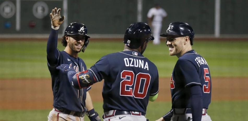 Marcell Ozuna (20) de los Bravos de Atlanta celebra con sus compañeros de equipo Dansby Swanson, a la izquierda, y Freddie Freeman (5) después de que todos anotaron con el jonrón de tres carreras de Ozuna durante la octava entrada de un juego de béisbol contra los Medias Rojas de Boston, el martes de septiembre. .1, 2020, en Boston.