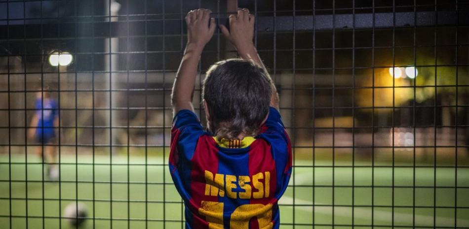 Un niño con una camiseta de Lionel Messi observa un partido de fútbol en Banyoles, España, el miércoles 2 de septiembre de 2020.
