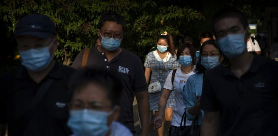 Peatones, con mascarilla para protegerse del coronavirus, pasean por una calle en un distrito comercial del centro de Beijing, el 2 de septiembre de 2020. (AP Foto/Mark Schiefelbein)