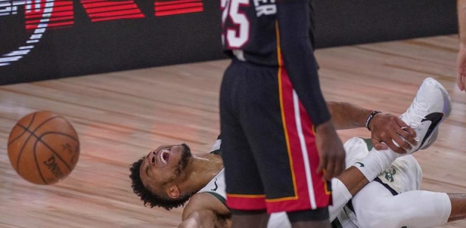 Giannis Antetokounmpo de los Bucks de Milwaukke reacciona tras lastimarse el tobillo durante la primera mitad del juego de la NBA contra el Heat de Miami, ayer en Florida. (AP)